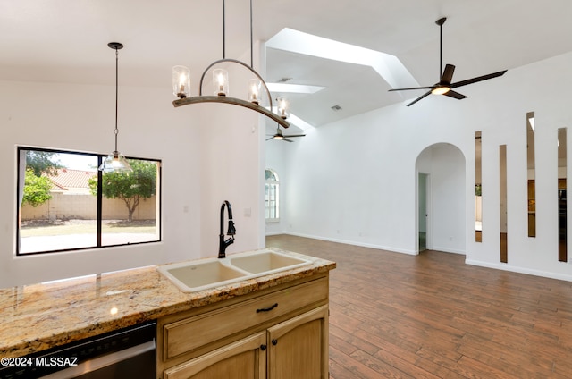 kitchen featuring dishwasher, sink, ceiling fan with notable chandelier, hanging light fixtures, and dark hardwood / wood-style flooring