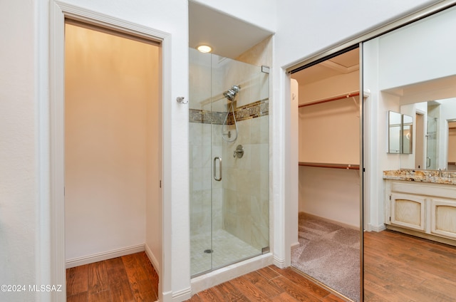 bathroom featuring a shower with door, hardwood / wood-style flooring, and vanity