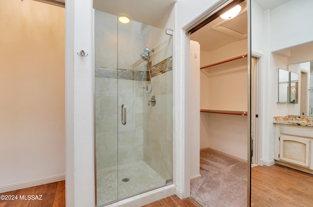 bathroom featuring wood-type flooring, vanity, and a shower with door