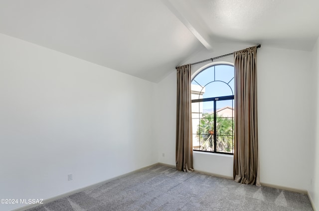 empty room with lofted ceiling with beams, light carpet, and a wealth of natural light