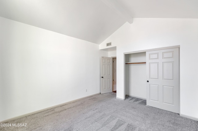 unfurnished bedroom with high vaulted ceiling, beam ceiling, light carpet, and a closet