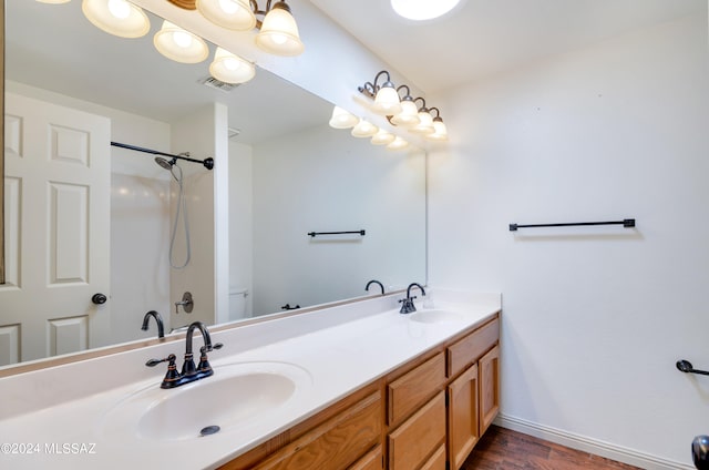 bathroom with wood-type flooring, vanity, a shower, and toilet