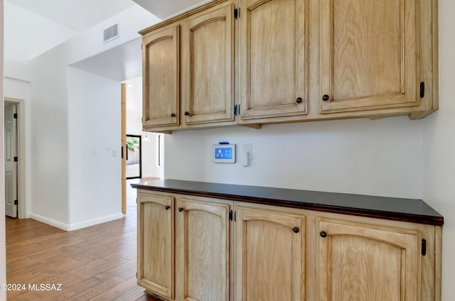 kitchen featuring light brown cabinetry and hardwood / wood-style floors