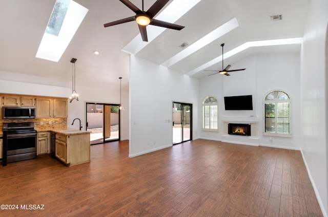 living room featuring dark hardwood / wood-style floors, ceiling fan, sink, and high vaulted ceiling