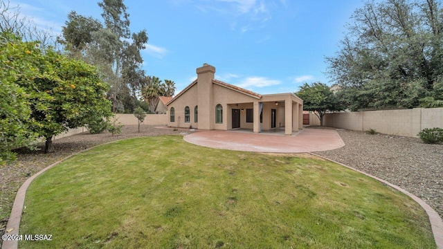 rear view of property featuring a yard and a patio area