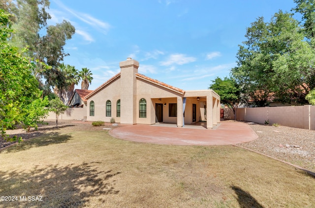 rear view of house featuring a yard and a patio