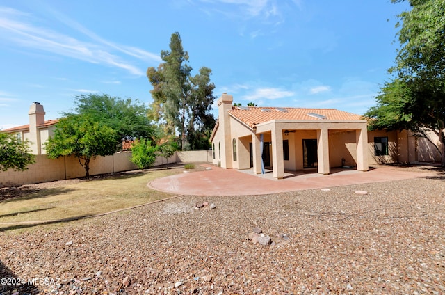 rear view of house featuring a lawn and a patio area