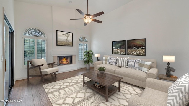 living room featuring ceiling fan, hardwood / wood-style flooring, and high vaulted ceiling