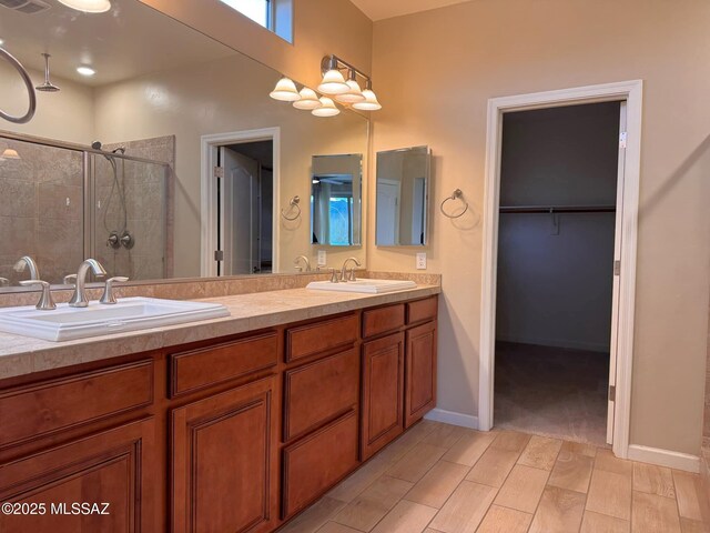 kitchen with sink, light stone countertops, ceiling fan, light hardwood / wood-style flooring, and dishwasher