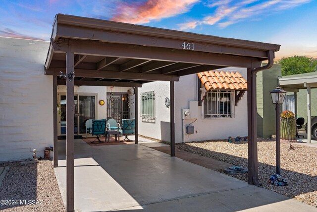 patio terrace at dusk featuring a carport