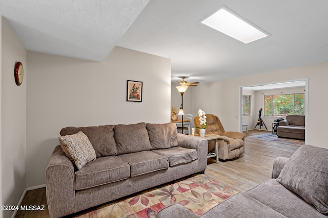 living room featuring ceiling fan and light hardwood / wood-style floors