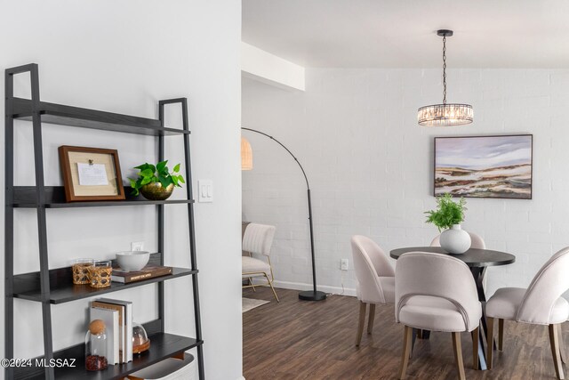 dining room with dark wood-type flooring and a chandelier