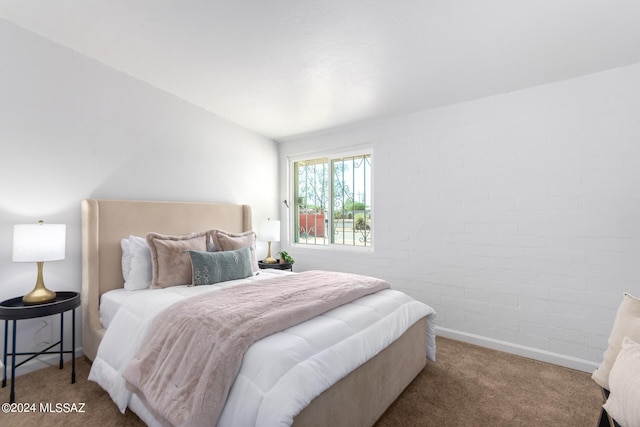 bedroom featuring carpet flooring and brick wall