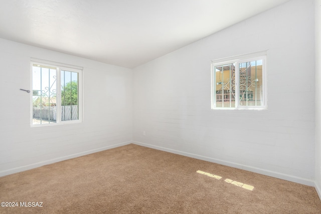 empty room with lofted ceiling and carpet floors