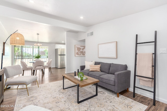 living room with an inviting chandelier and light hardwood / wood-style floors