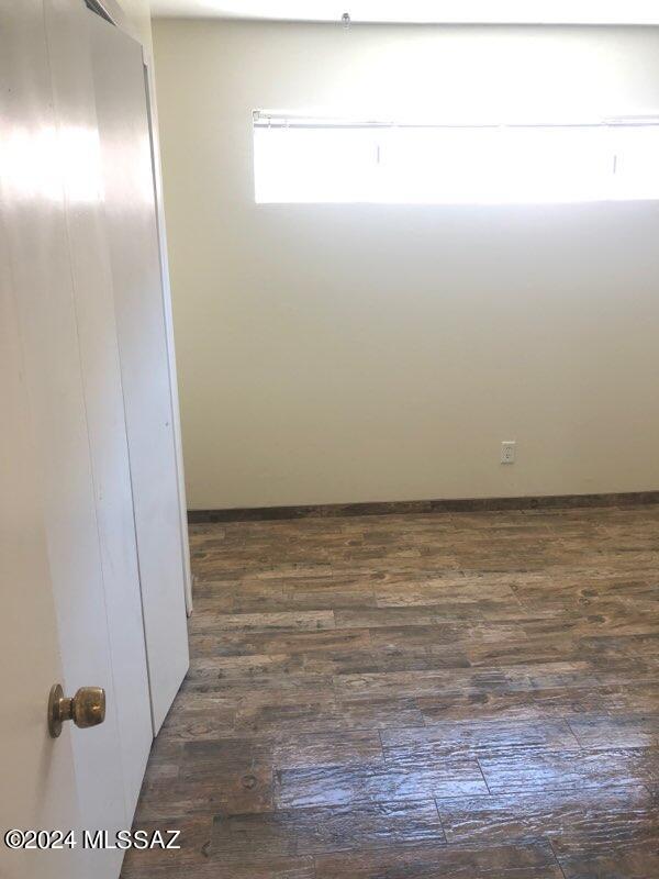 empty room with dark hardwood / wood-style flooring