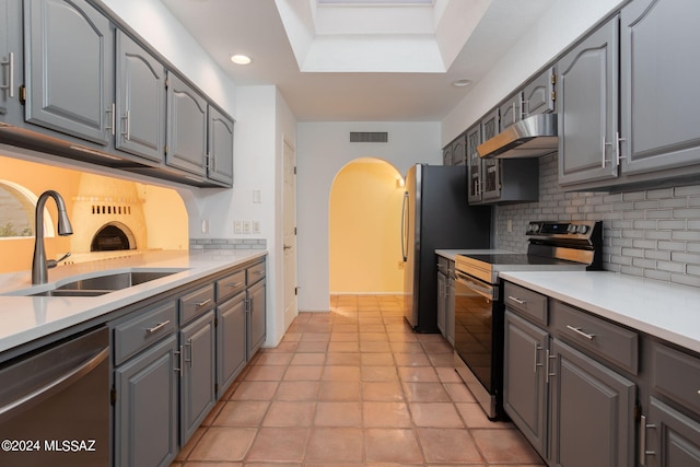 kitchen with stainless steel appliances, sink, gray cabinets, and tasteful backsplash