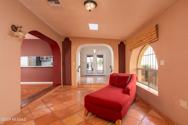 living area featuring french doors and tile patterned floors