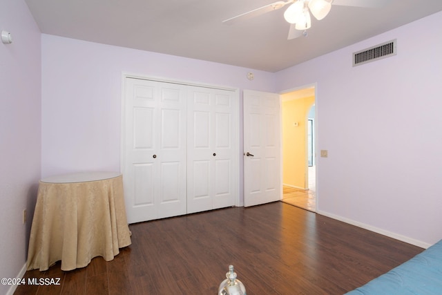 bedroom with ceiling fan, a closet, and dark hardwood / wood-style flooring