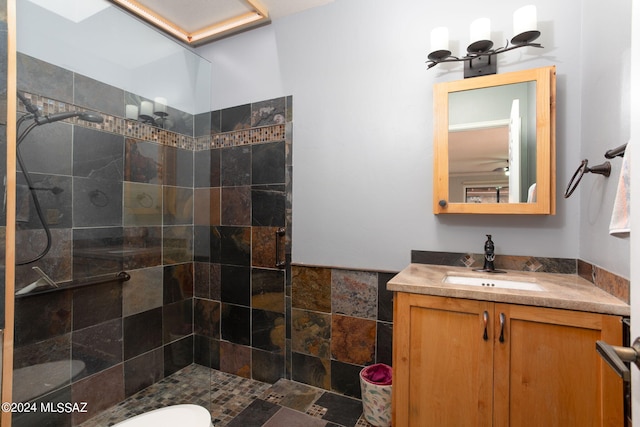 bathroom featuring vanity, toilet, and tiled shower