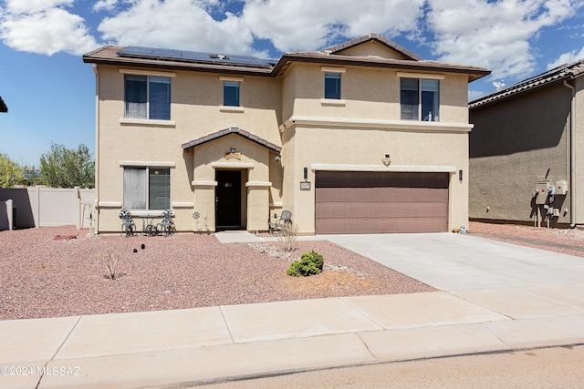 view of front of property with fence, concrete driveway, and stucco siding