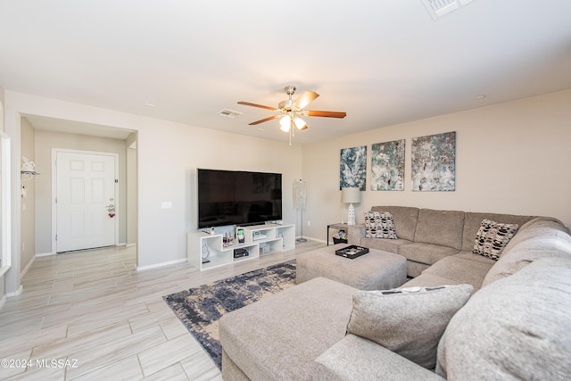 living area with baseboards, wood tiled floor, visible vents, and a ceiling fan