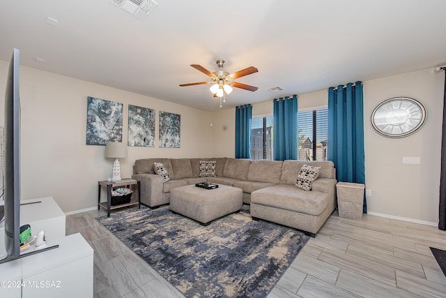 living area featuring visible vents, ceiling fan, and baseboards