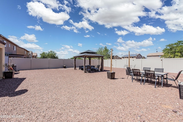 view of yard featuring a fenced backyard, outdoor dining area, a patio, and a gazebo