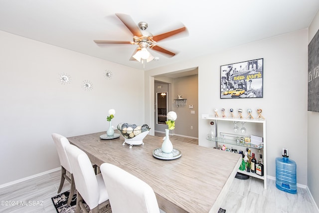 dining room featuring a ceiling fan and baseboards