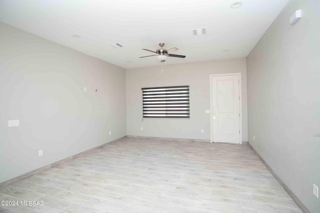 spare room with ceiling fan and light wood-type flooring