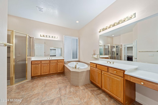 bathroom with a sink, a garden tub, two vanities, and a shower stall