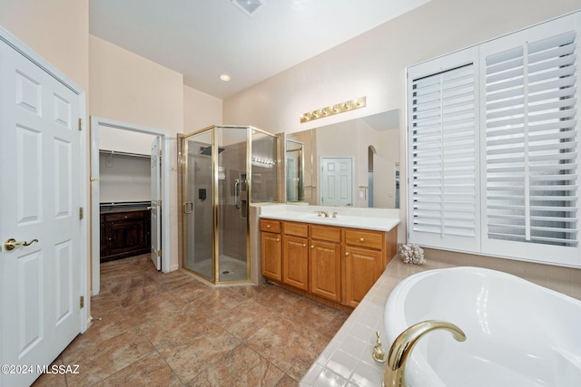 full bath with a spacious closet, visible vents, a shower stall, a garden tub, and vanity