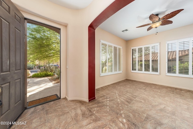 foyer entrance featuring a wealth of natural light, visible vents, baseboards, and a ceiling fan