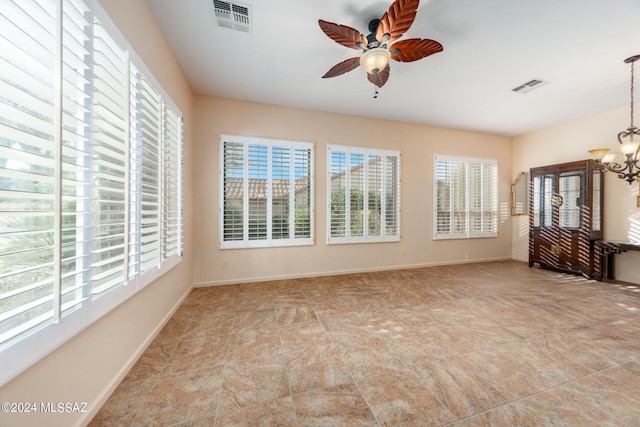 interior space with visible vents, baseboards, and ceiling fan with notable chandelier