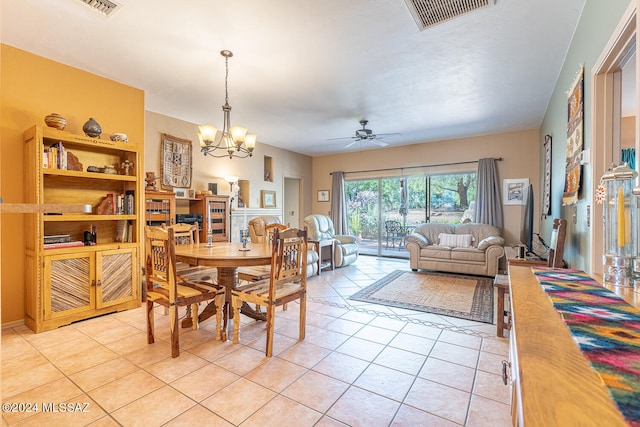 tiled dining room with ceiling fan with notable chandelier