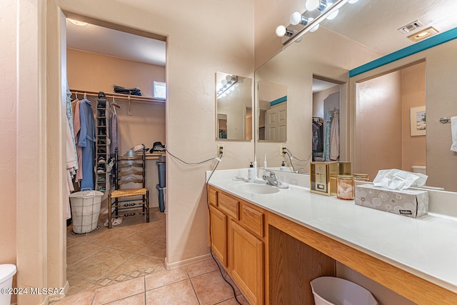 bathroom with vanity, toilet, and tile patterned floors