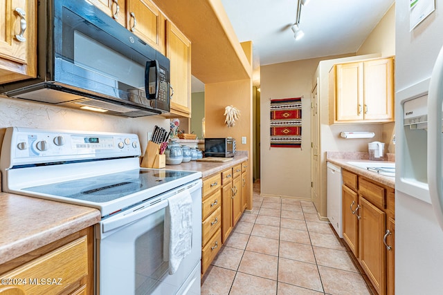 kitchen featuring rail lighting, white appliances, and light tile patterned floors