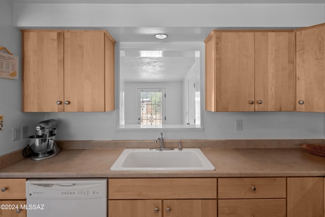 kitchen featuring light brown cabinetry, white dishwasher, and sink