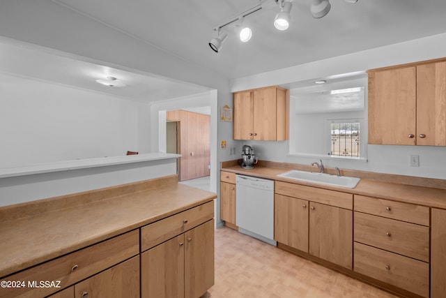 kitchen with light brown cabinetry, dishwasher, and sink