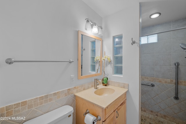 bathroom with tiled shower, vanity, and toilet