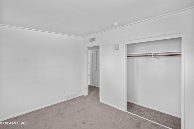 unfurnished bedroom featuring light colored carpet and a closet