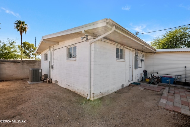 rear view of property with central AC