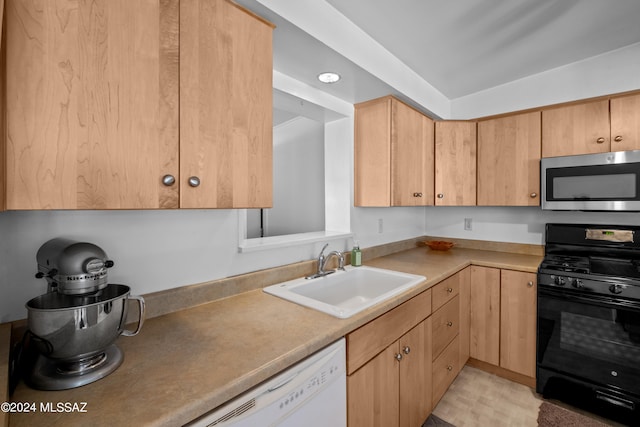 kitchen featuring white dishwasher, sink, light brown cabinets, and black gas range