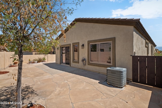 rear view of property featuring a patio and central air condition unit