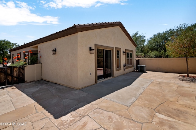 rear view of property with a patio area and central AC