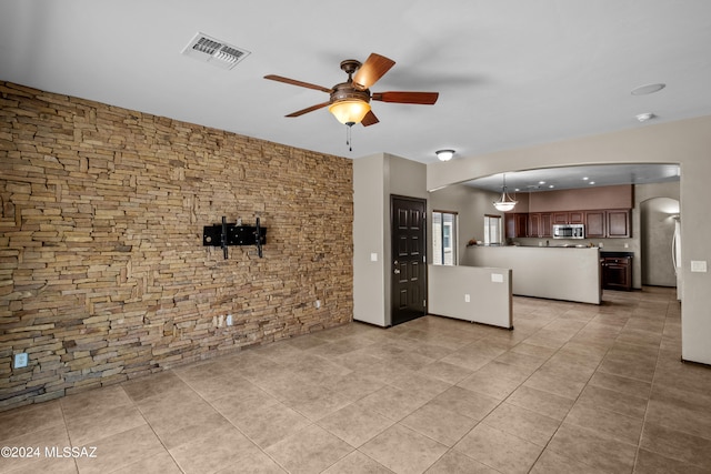 unfurnished living room featuring light tile patterned floors and ceiling fan