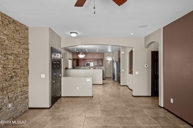 kitchen featuring appliances with stainless steel finishes, light tile patterned flooring, ceiling fan, and hanging light fixtures