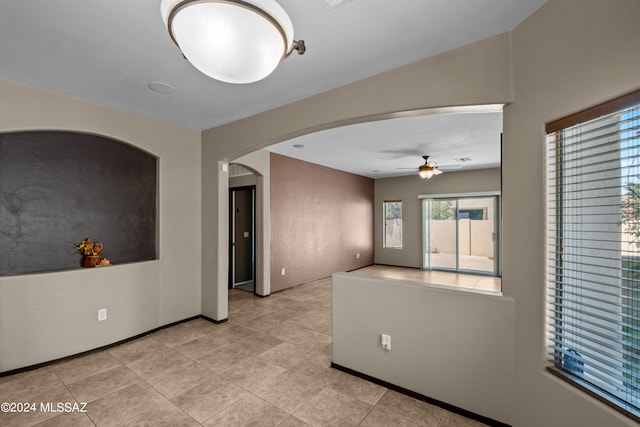 spare room featuring ceiling fan and light tile patterned flooring