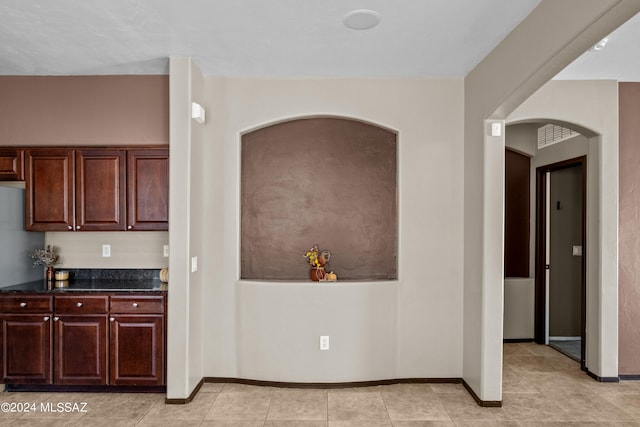 kitchen with dark stone counters and light tile patterned flooring