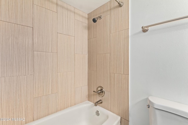 bathroom with toilet and tiled shower / bath